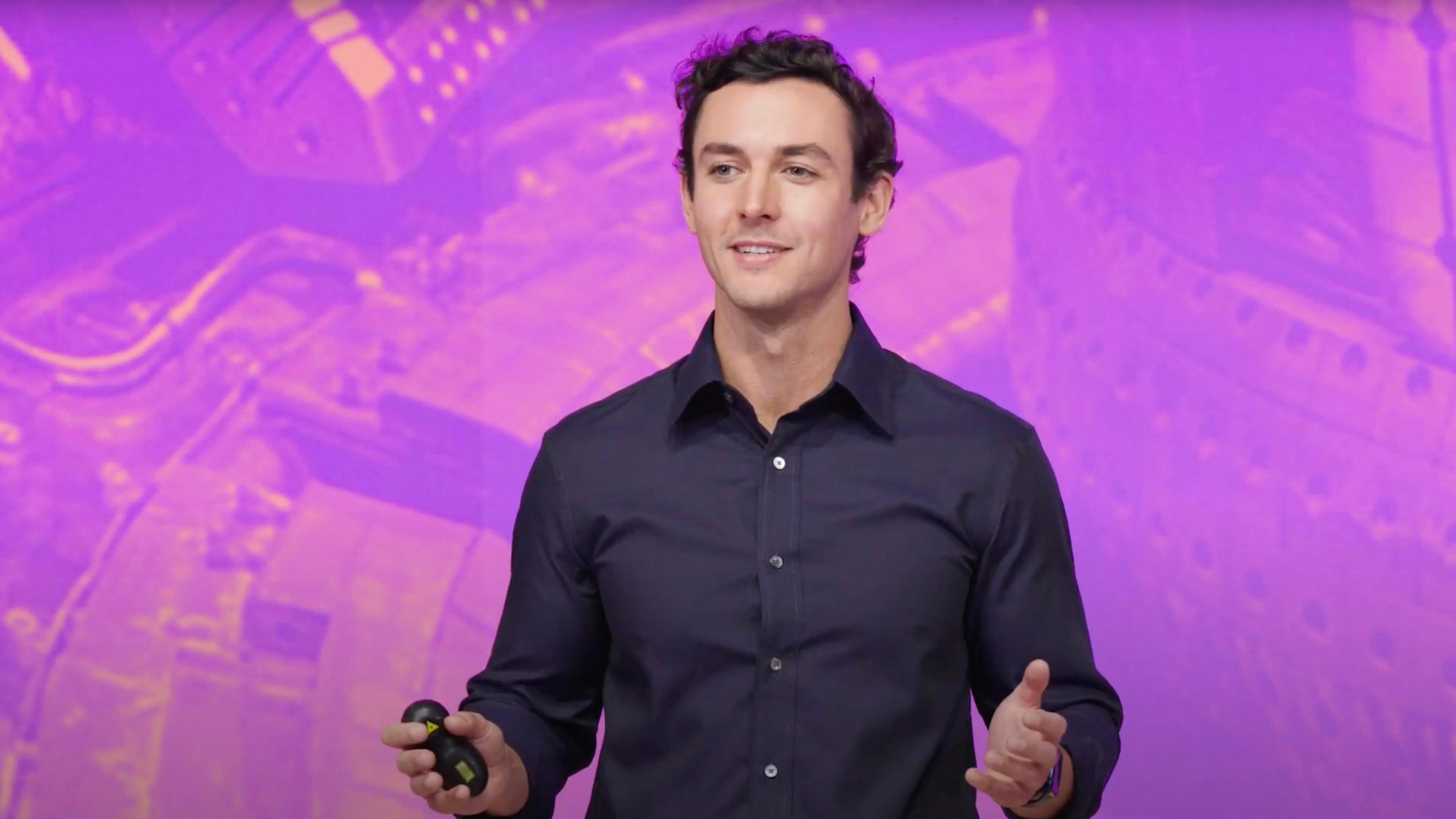 Julien Barber in front of a textured purple and pink background