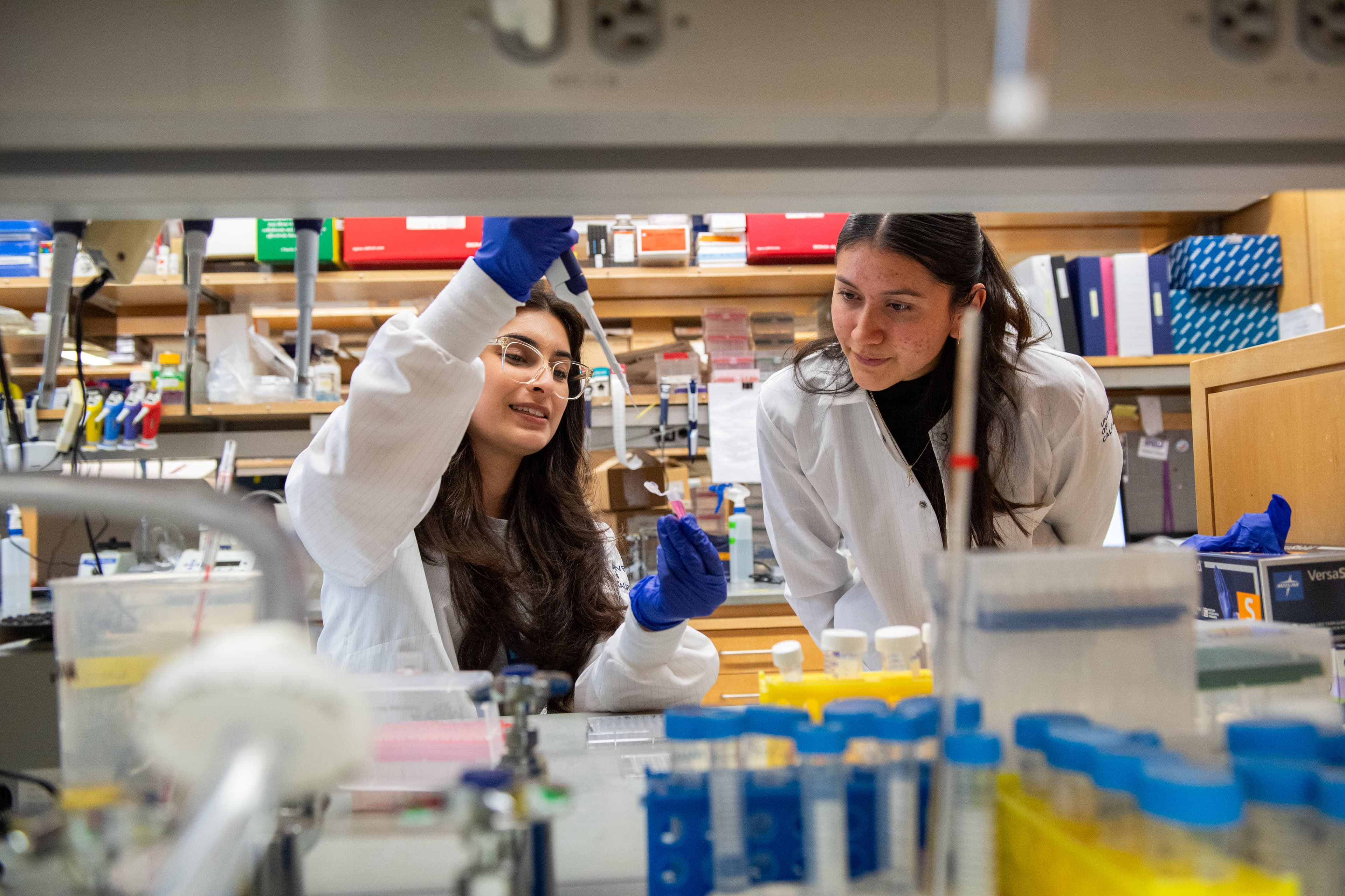 Two scientists using a pipette